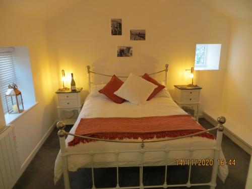 Un dormitorio con una cama con almohadas rojas. en Pengelly - Luxury converted Fisherman’s Net Loft, en Mousehole