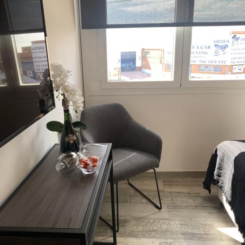 a room with a table with a chair and a bottle of wine at Hotel Riojano in Humanes de Madrid