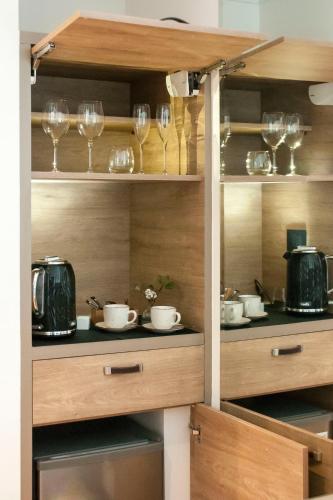 a kitchen with wooden shelves with glasses and dishes at Pura Lodge in Concepción