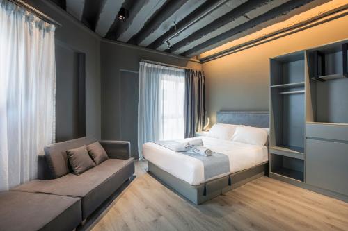 a bedroom with a bed and a couch at Hotel Calmo Bugis in Singapore