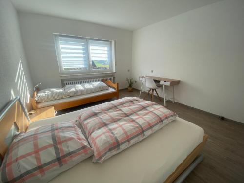 a bedroom with a bed and a desk and a window at Ferienwohnung Wasserturmblick in Bebra