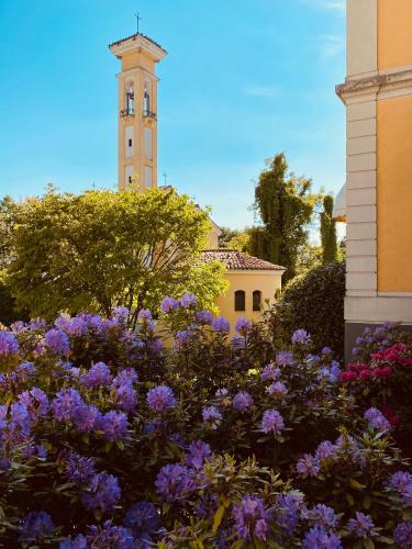 a garden with purple flowers in front of a building at Hotel Villa Malpensa in Vizzola Ticino