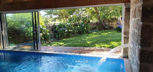 a swimming pool with a view of a yard at Casas de Campo da Barroca in Tabosa
