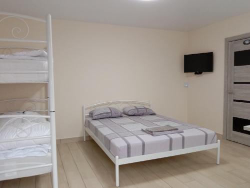 a white bedroom with a bed and bunk beds at Однокімнатна 105 in Khmelʼnytsʼkyy