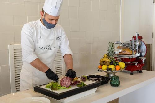 a chef preparing a meal in a kitchen at Mec Paestum Hotel in Paestum