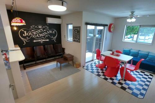 a living room with a table and red chairs at Ts square in Ginowan