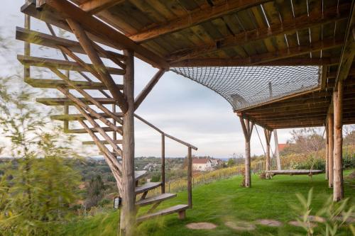 a wooden pergola with stairs and a bench at AISLAMIENTO, Luxus faház in Zalaegerszeg