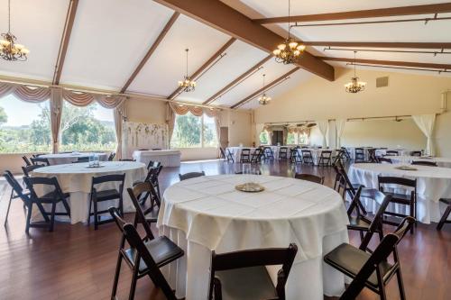 a banquet hall with white tables and chairs at Carlton Oaks Lodge, an Ascend Collection Hotel in Santee