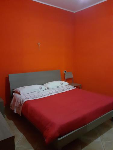 un letto in una camera con parete arancione di B & B Residence L'Ancora a Villapiana
