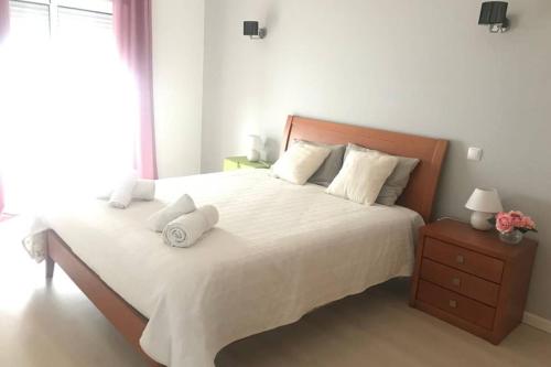 a bedroom with a large bed with white sheets and pillows at T2 Ferragudo Cosy Beach Apartment in Ferragudo