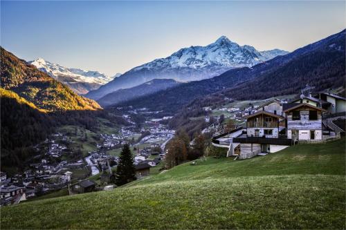 a town on a hill with mountains in the background at Chalets - The Peak in Sölden