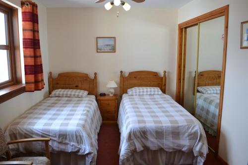 a bedroom with two beds and a mirror at Balhousie Farm Bed and Breakfast in Kirkton of Largo