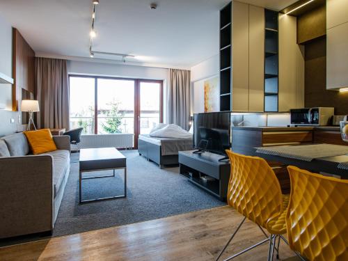 TATRA SUITES Luxury Studio A304 في ستاري سموكوفيتش: غرفة معيشة مع أريكة وغرفة معيشة مع أريكة
