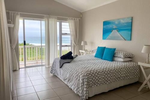 Schlafzimmer mit einem Bett und Meerblick in der Unterkunft Tamassa Holiday Home on the Beach, in Port Edward in Port Edward