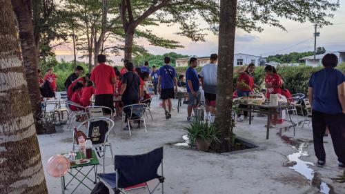 a group of people standing around tables and chairs at 鐵騎休息棧 in Fangliao