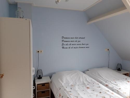 sypialnia z łóżkiem i znakiem na ścianie w obiekcie Vakantiewoning 100m van het strand met 1 Slaapkamer w mieście Westkapelle