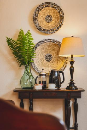 a table with a lamp and a vase with a plant on it at Puertas in Vieques