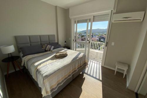 ein Schlafzimmer mit einem Bett und einem Balkon in der Unterkunft Jurere Internacional Ibiza in Florianópolis
