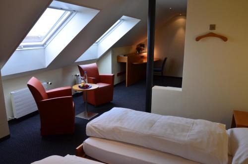 a hotel room with a bed and a table and chairs at Hotel Urs und Viktor in Bettlach