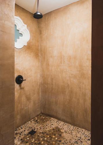 a shower in a bathroom with a concrete wall at Puertas in Vieques