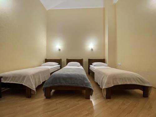 a group of four beds in a room at Passage Hotel in Ternopilʼ