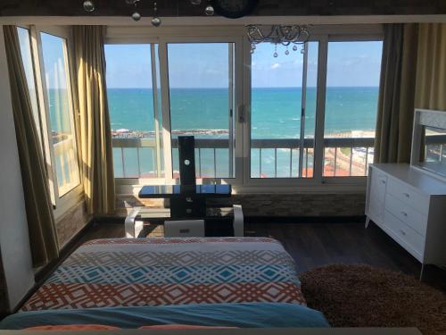 a bedroom with a bed and a view of the ocean at Blue Bay Beach-Families only in Alexandria