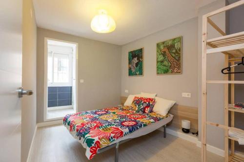 una camera con un letto con una coperta colorata di AGUSTINA - Piso céntrico reformado en calle peatonal a Saragozza