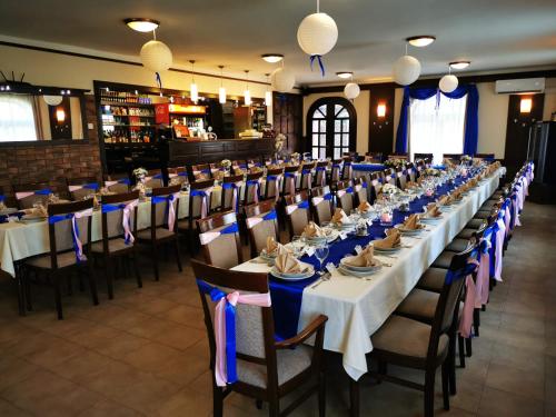 a large dining room with long tables and chairs at Patyi Étterem és Hotel in Bögöte