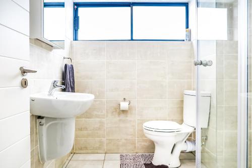 a bathroom with a toilet and a sink at Insaka's 2 Greenlee Apartment - Greenlee Lifestyle Centre, Sandton in Sandown
