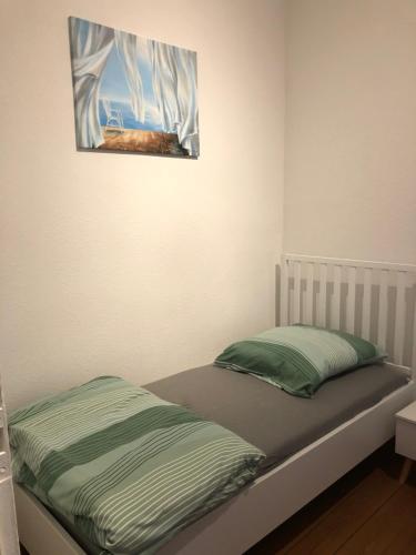 ein Bett in einem Zimmer mit einem Gemälde an der Wand in der Unterkunft Apartment am Schelfmarkt in Schwerin