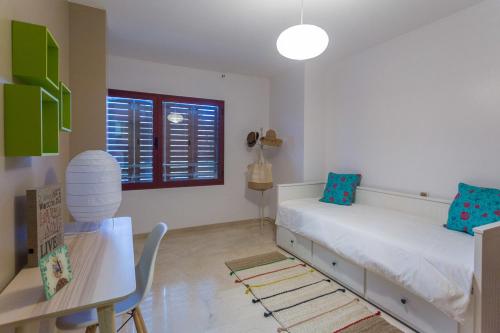 ラスパルマス・デ・グランカナリアにあるApartment NOUMELYAのベッドルーム1室(ベッド1台、デスク、テーブル付)