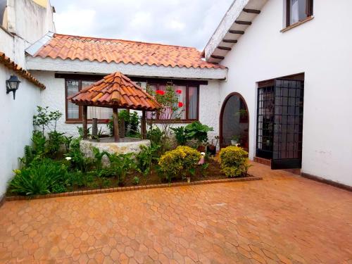 a white house with a courtyard with a gazebo at Villa Suite Emanuel in Bogotá