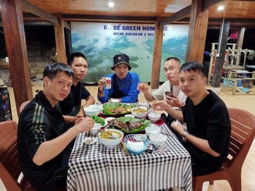 a group of people sitting at a table eating food at Ba Be Green Homestay in Bak Kan