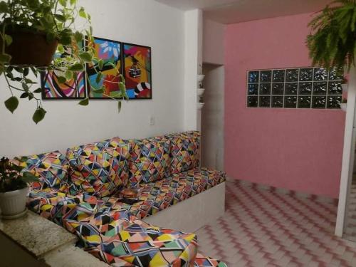 a living room with a couch and a pink wall at Space Hostel , quartos privativos in Arraial do Cabo