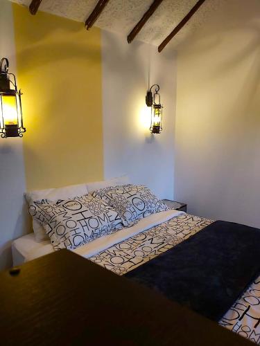 a bed in a room with two lights on the wall at Villa Suite Emanuel in Bogotá