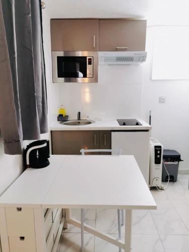 - une cuisine avec une table blanche et un évier dans l'établissement Agréable studio à proximité de Paris et Henri Mondor, à Créteil