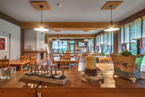 a dining room with a table and chairs and windows at Casa Muntelui in Fundata