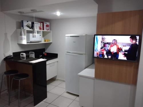 a kitchen with a flat screen tv in a kitchen at Parque ALDEIA DAS ÁGUAS Village flat in Barra do Piraí