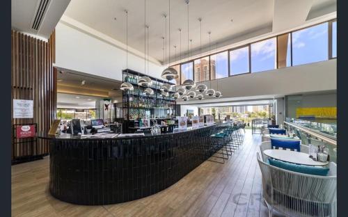 a restaurant with a bar with blue stools at High Floor Ocean View at Surfers Paradise - Hotel Studio in Gold Coast