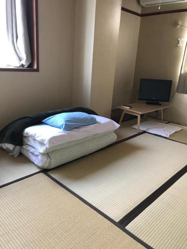 a small bedroom with a bed and a desk at 鏡水旅館/kyousuiryokan in Kochi