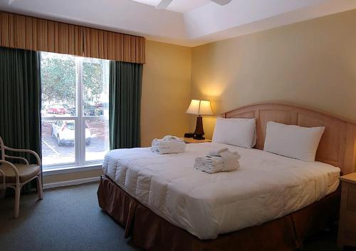 Un dormitorio con una cama grande con toallas. en Ocean Palms Villa with Championship Golf Saturday to Saturday Rental, en Hilton Head Island