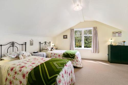 a bedroom with two beds and a window at Country Villa Estate in Ngongotaha