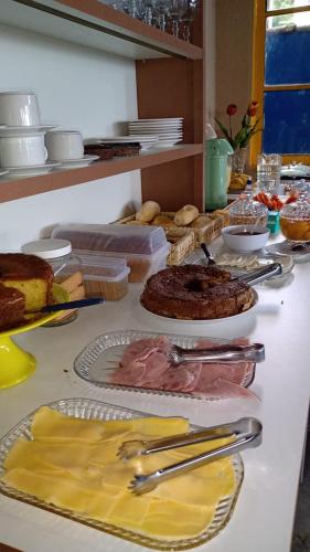 einen Tisch mit Teller mit Lebensmitteln auf einer Theke in der Unterkunft Pousada da Ponte in Praia de Araçatiba