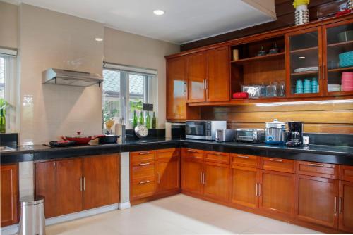 a kitchen with wooden cabinets and black counter tops at Hotel Kimberly Tagaytay in Tagaytay