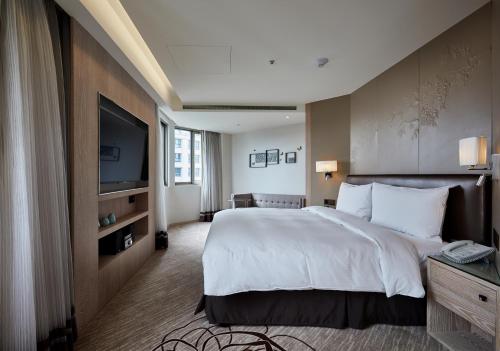 a hotel room with a large bed and a television at K Hotel Taipei Chang-An in Taipei