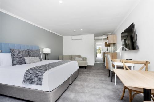 a hotel room with a bed and a dining room at Sanctuary Inn on Westernport in Hastings