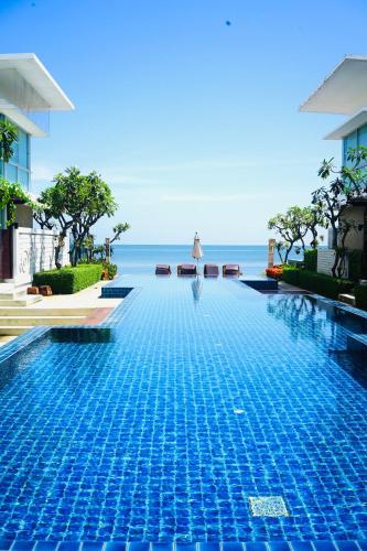 a swimming pool with the ocean in the background at Pool Villa at Vimanlay in Cha Am