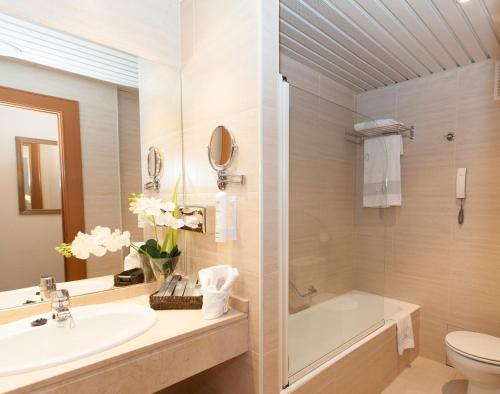 y baño con lavabo, aseo y bañera. en Hotel los Bracos by Silken, en Logroño