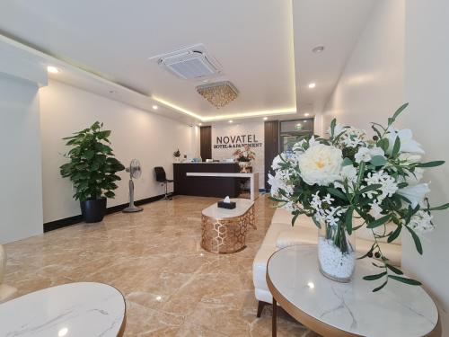 a lobby with a waiting room with white flowers in a vase at Novatel Hotel & Apartment in Hai Phong