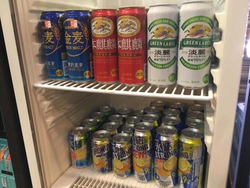 a refrigerator filled with lots of different types of drinks at Capsule Land Yushima (Male Only) in Tokyo